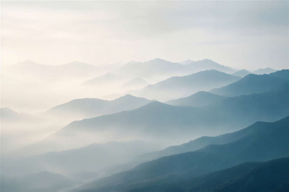 Fototapeten Morgennebel über den Berggipfeln