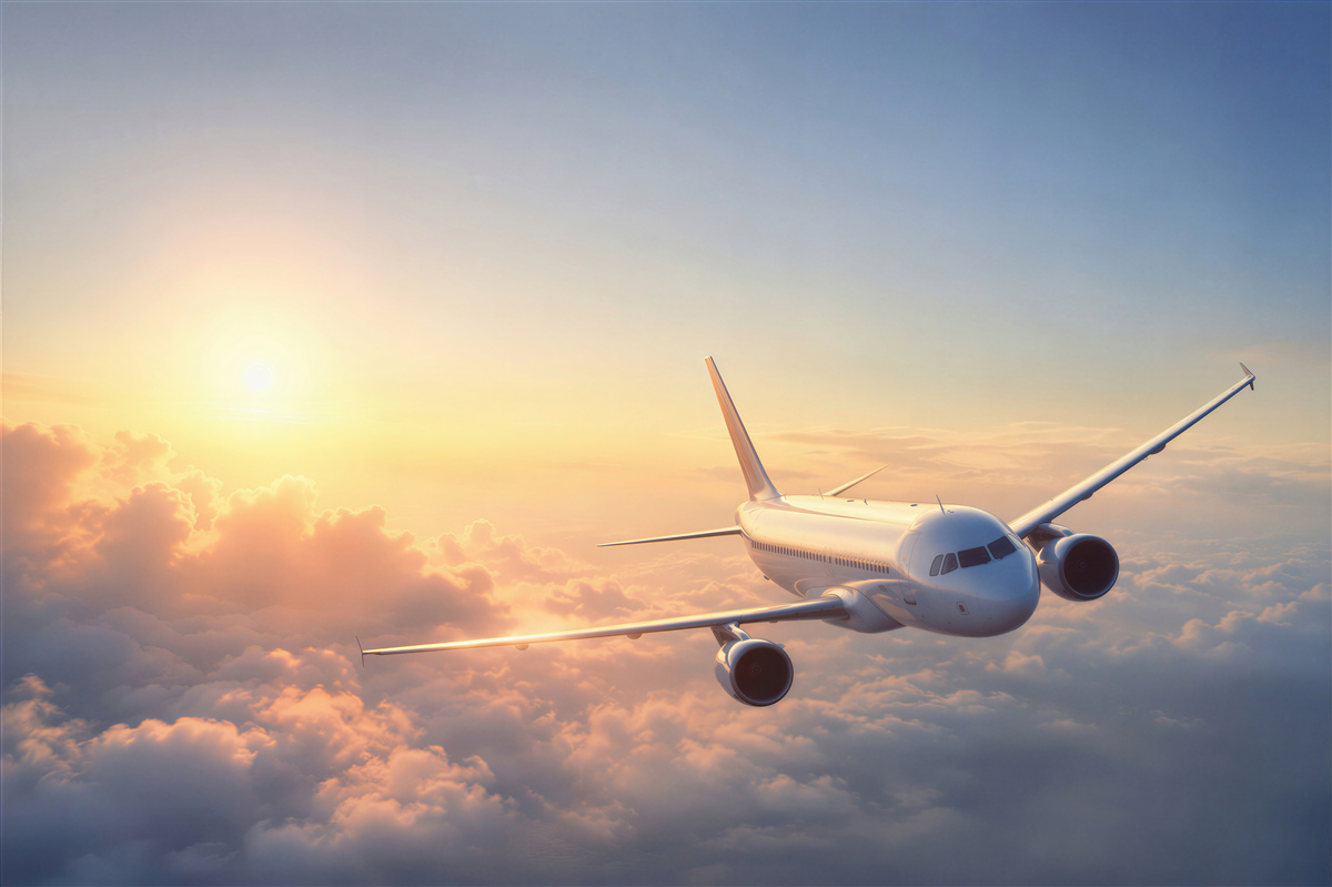 Fototapeten Flugzeug fliegt in den Sonnenuntergang